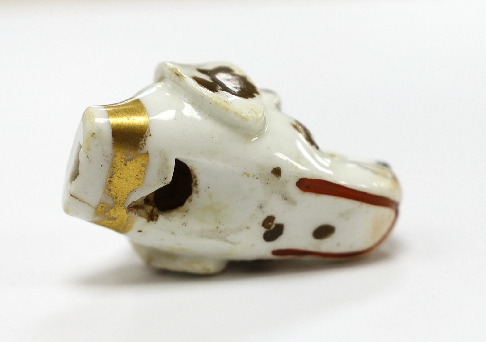 An early 19th century Staffordshire porcelain dog’s head whistle, 4.5cm